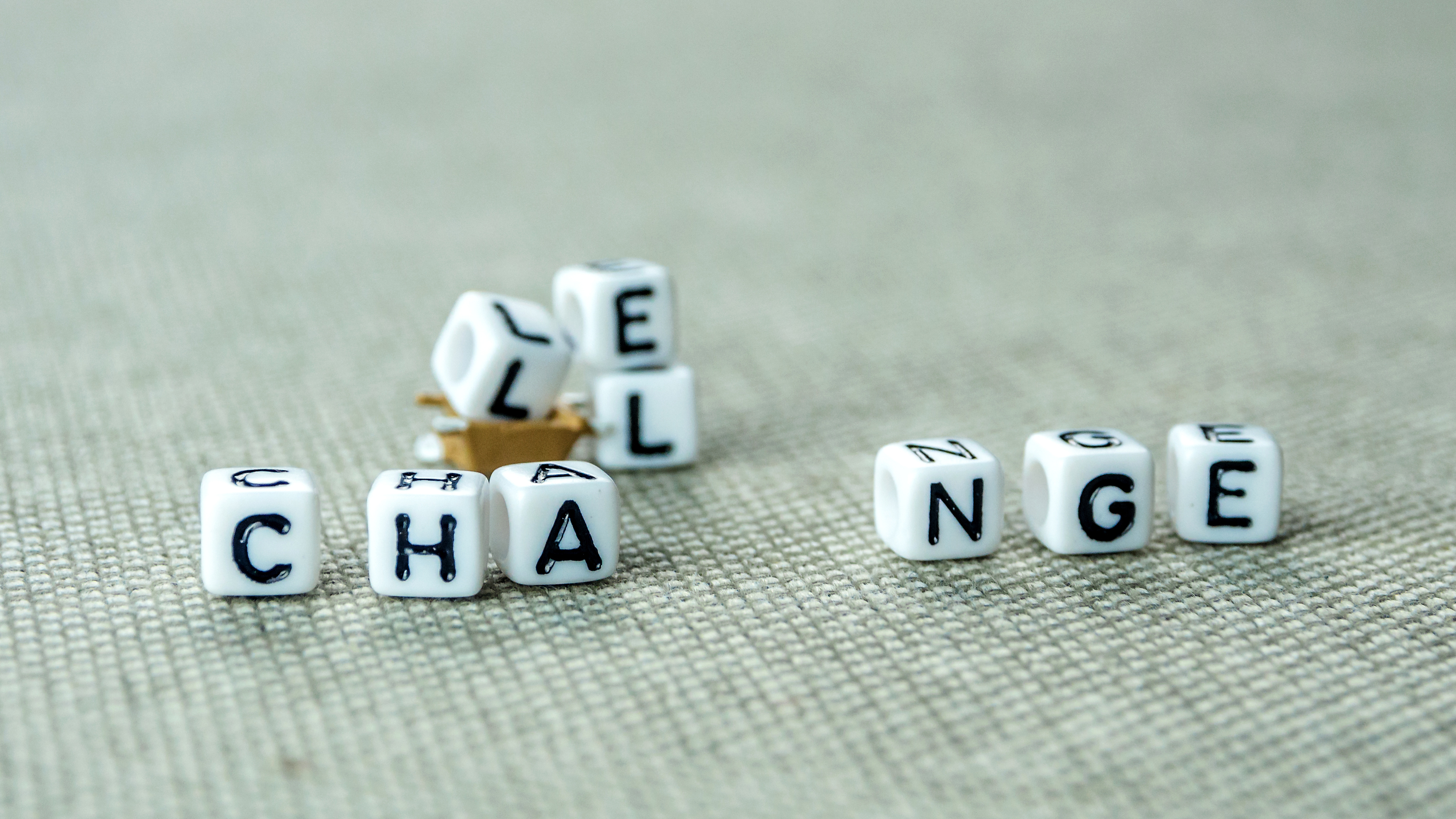 White Cubes With Word Challenge Creating New Word Change, Personal Development And Career Growth Or Challenge Yourself Concept, Grey Background With Miniature Figurines Watching At It